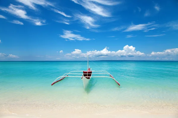 Белая лодка на тропическом пляже — стоковое фото