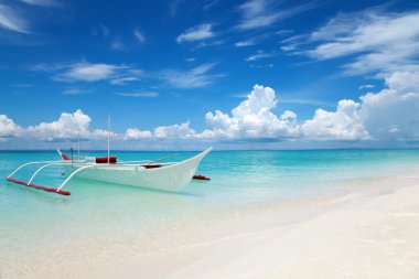 White boat on a tropical beach clipart