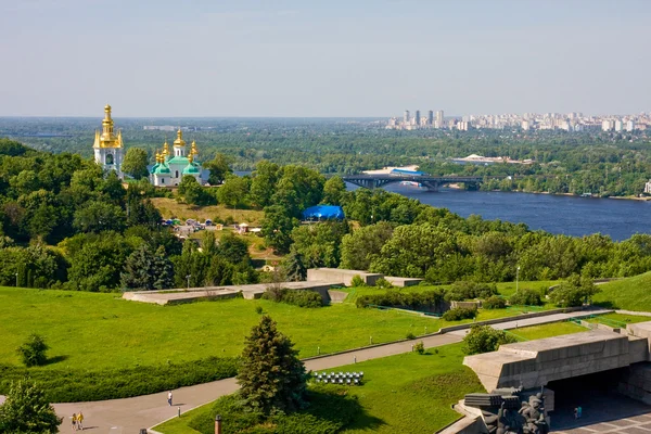 Vista da igreja no mosteiro Lavra, rio Dnieper e área moderna em Kiev, Ucrânia — Fotografia de Stock