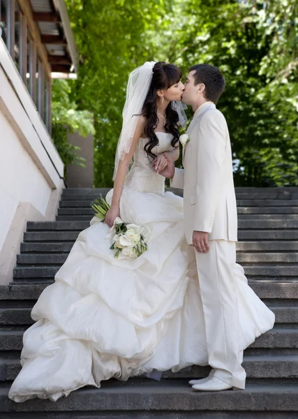 Gelukkige bruid en bruidegom in een park op hun trouwdag — Stockfoto