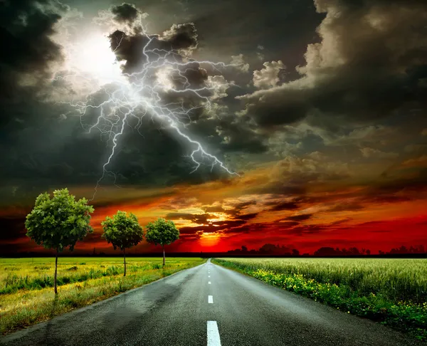 Асфальтовая дорога и молния — стоковое фото