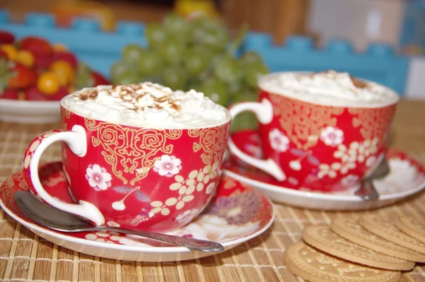 Two cups of cappuccino with cream