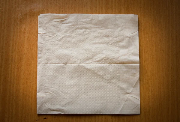 Beige cocktail napkin on wooden Stock Image