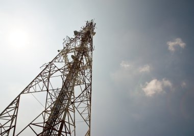 Modern cell and antenna with flat parabola on blue sky clipart