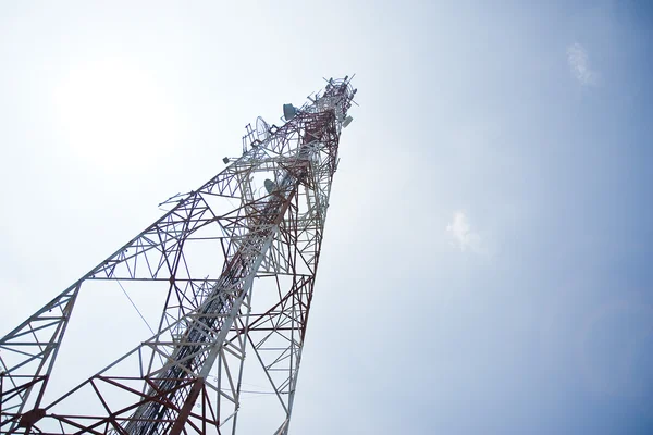 Cellula moderna e antenna con parabola piatta su cielo blu — Foto Stock