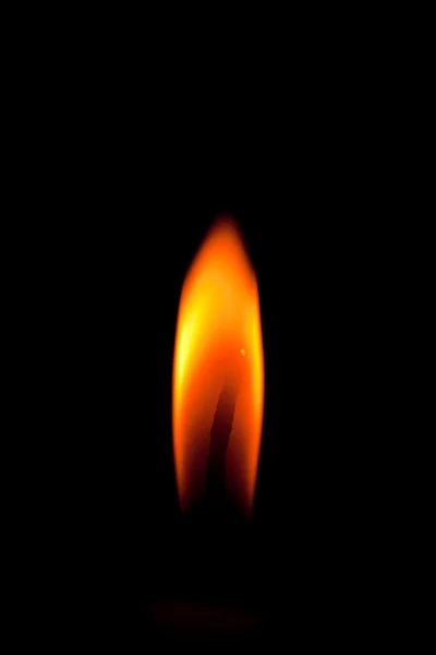 Крупный план горящей свечи на черном фоне — стоковое фото