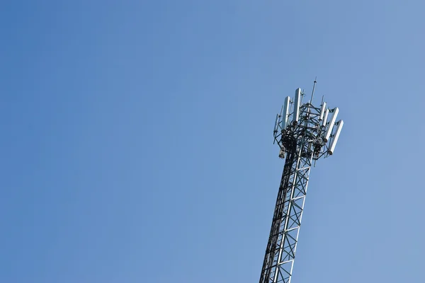 Torre del teléfono celular se levanta contra un cielo azul . — Foto de Stock