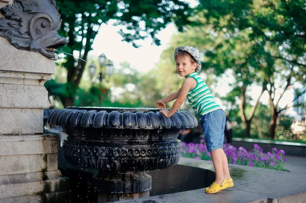 Хлопчик біля фонтану — стокове фото