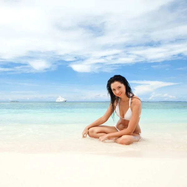 Счастливая молодая женщина отдыхает на пляже — стоковое фото