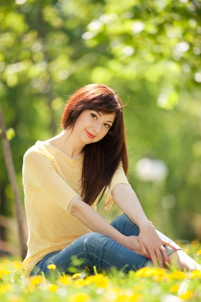 Молодая женщина в парке с цветами — стоковое фото