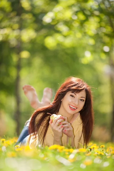 Szczęśliwa kobieta z gruszką w parku — Zdjęcie stockowe