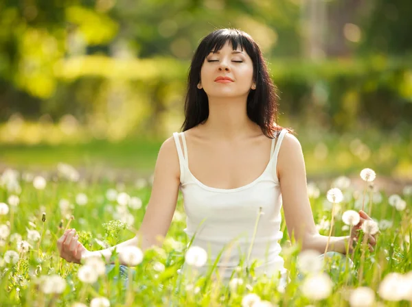 Красивая женщина медитирует в парке — стоковое фото