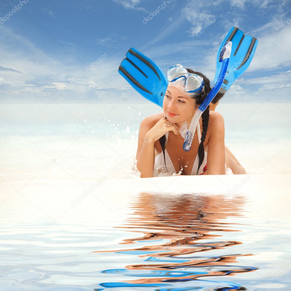 Happy woman with snorkeling equipment on the beach