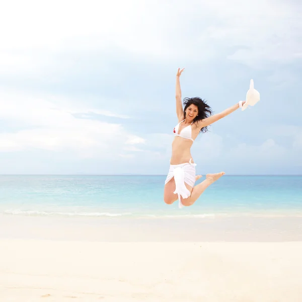 Felice giovane donna che salta sulla spiaggia del mare — Foto Stock