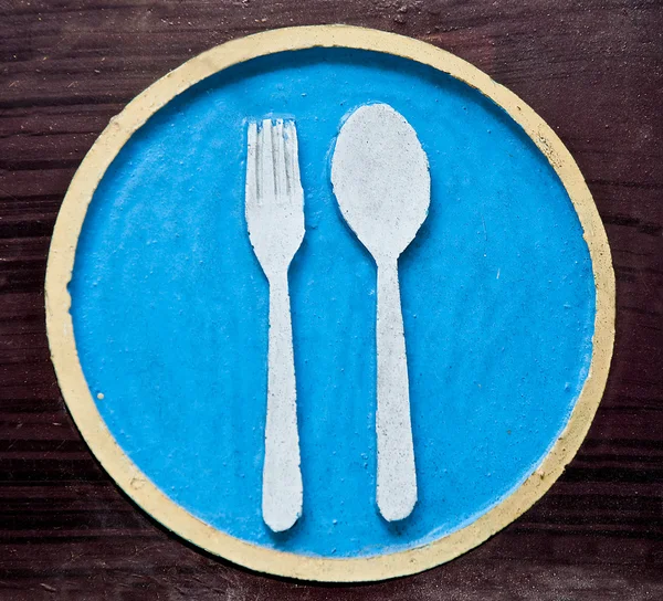El signo de tenedor y cuchara en el plato — Foto de Stock
