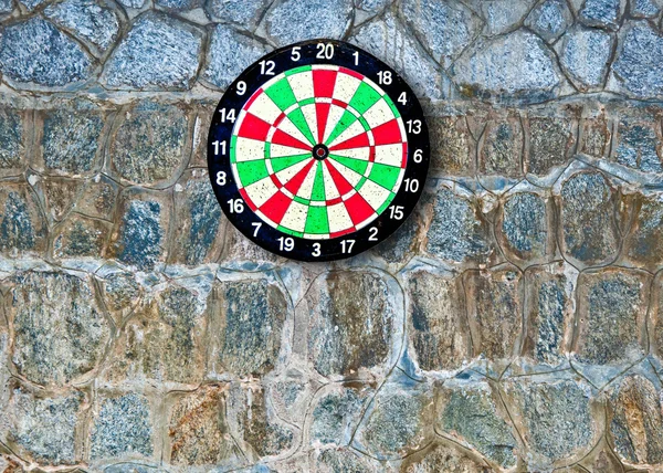 The Dartboard on rock wall background — Stock Photo, Image