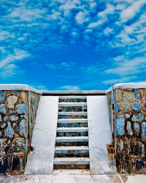Trappan ner till stranden på blå himmel bakgrund — Stockfoto