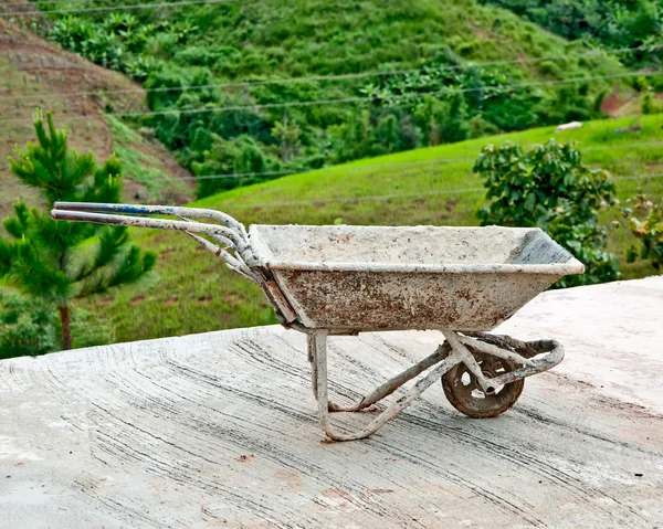 O velho carrinho de mão no fundo da montanha — Fotografia de Stock