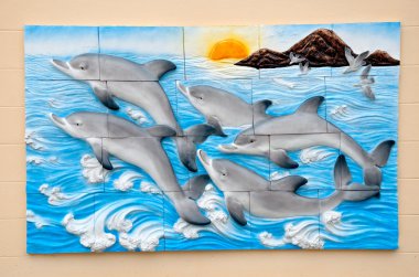 The Carving sandstone of dolphins on wall background clipart