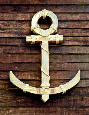 The Old wooden anchor on wood wall background clipart