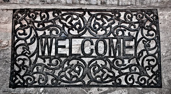 O Doormat aço curvo de texto de boas-vindas no fundo do chão — Fotografia de Stock