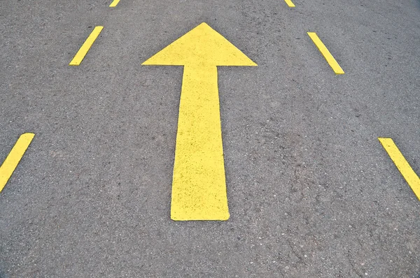 A seta amarela encaminhada na estrada — Fotografia de Stock