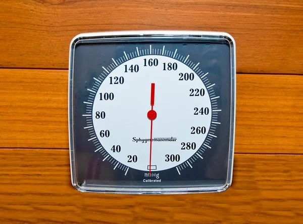 Das Blutdruckmessgerät an der Holzwand — Stockfoto