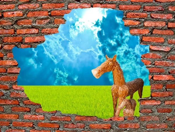 Дерев'яний кінь з руйнуванням цегляної стіни на синьому фоні — стокове фото
