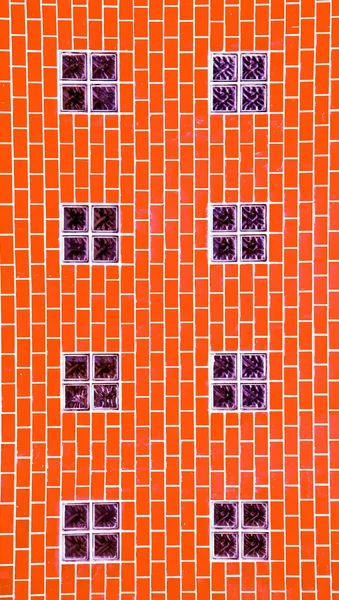 O bloco de vidro na parede de tijolo laranja — Fotografia de Stock