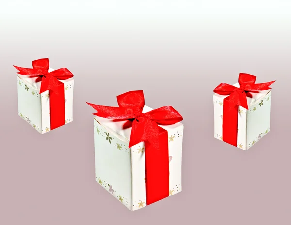 Τα κουτιά δώρο με κόκκινη κορδέλα που απομονώνονται σε γκρι φόντο — Φωτογραφία Αρχείου