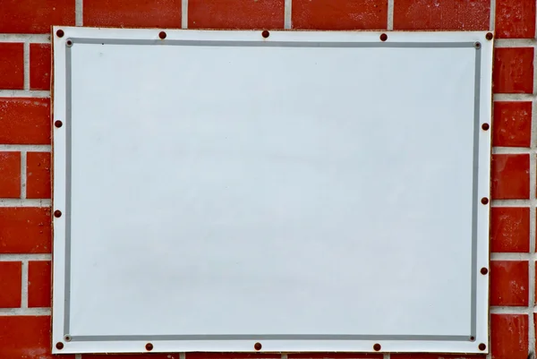 O cartaz branco pronto para texto no fundo da parede de tijolo — Fotografia de Stock