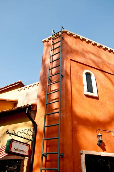 La escalera De acero hasta la pared de hormigón con el fondo azul del cielo —  Fotos de Stock