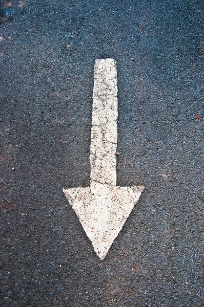 La freccia bianca sullo sfondo della strada — Foto Stock
