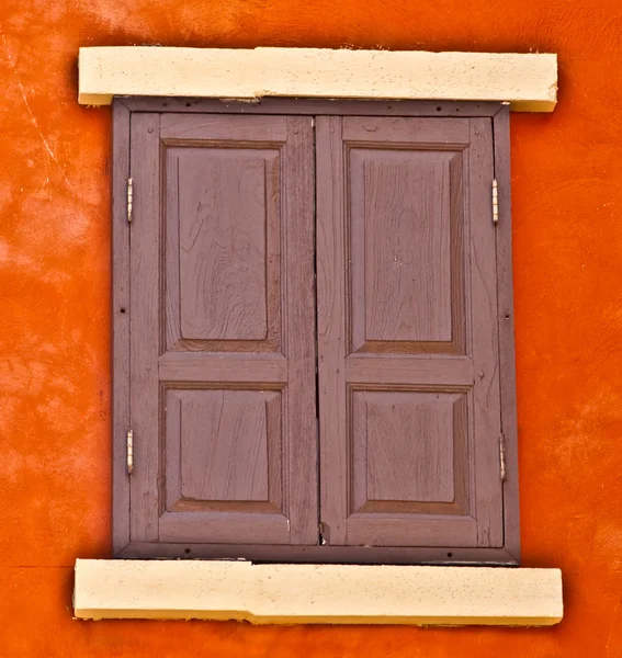 Винтажное окно на фоне оранжевой стены — стоковое фото