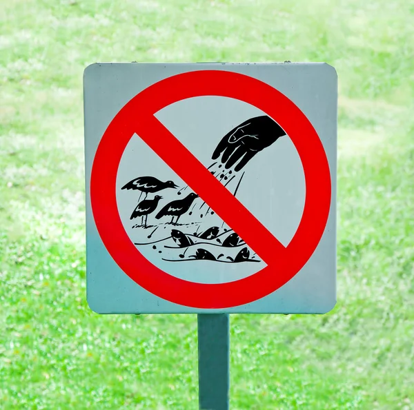 Le signe de ne pas nourrir les oiseaux et les poissons sur fond d'herbe verte — Photo