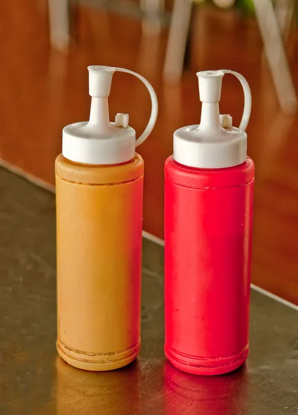 Botella de mostaza y ketchup en la mesa de comedor — Foto de Stock