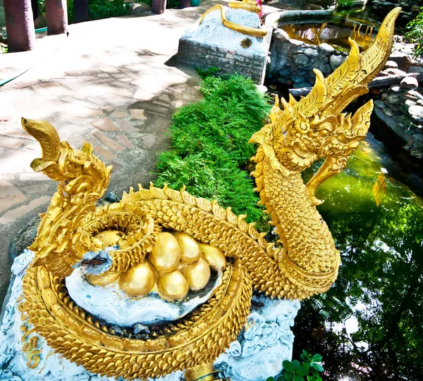Die goldene Nagaskulptur mit goldenen Eiern — Stockfoto