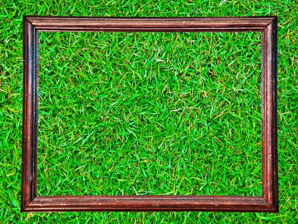 绿草背景上孤立的老式木制框架 — 图库照片