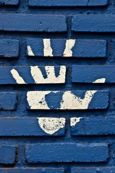 La mano de impresión blanca sobre fondo de pared azul — Foto de Stock