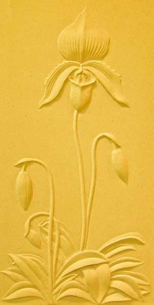 De sculptuur zandsteen van bloem op gele achtergrond — Stockfoto