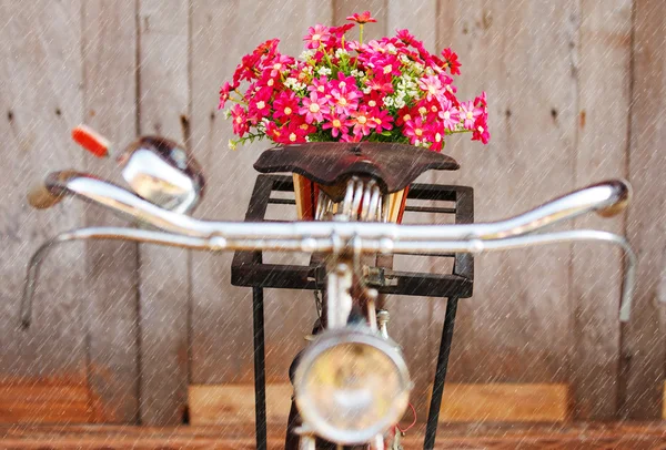 Artificial flowers on bicycle in rainy day — Stock Photo, Image