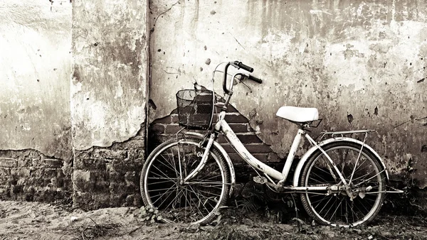 Vieja bicicleta y pared agrietada —  Fotos de Stock