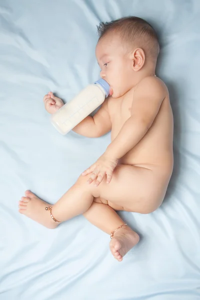 Baby boy holding milk bottle — Stock Photo, Image