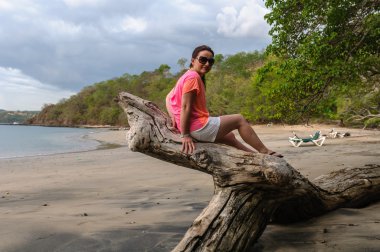 kütük üzerinde oturan mutlu kadın