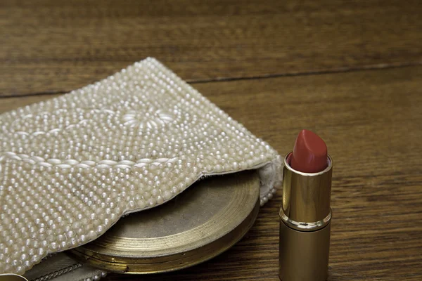 Lápiz labial rojo caliente, bolso de perlas con cuentas y polvo antiguo compacto — Foto de Stock