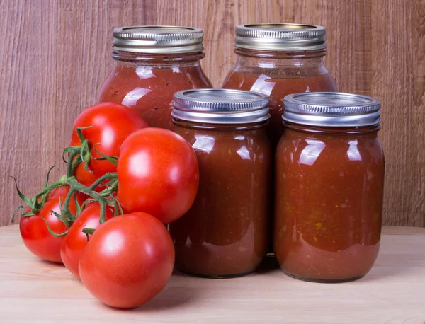 Tomato sauce in jars and tomatoes — Stock Photo, Image