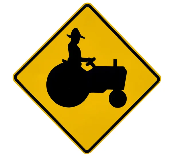 拖拉机横过黄色交通警告标志 — 图库照片