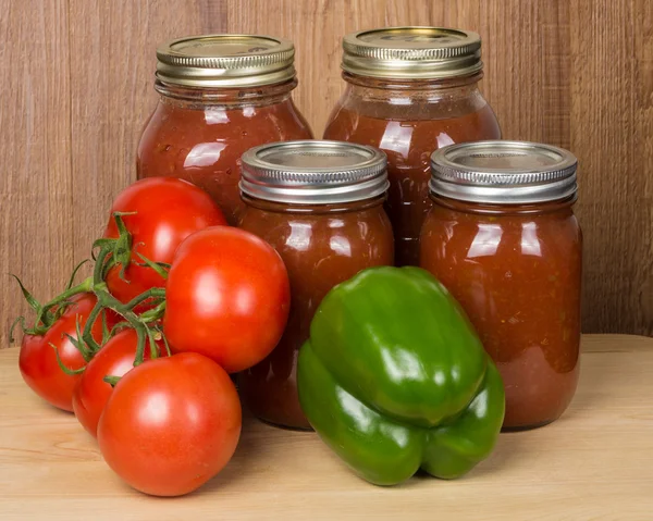 Tomato sauce in jars with tomatoes and peppers — Stock Photo, Image