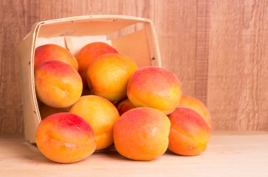 Basket of apricots on wooden table