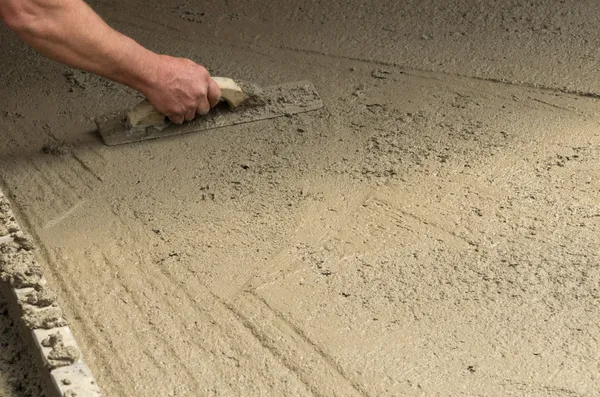 Travailleur finissant un plancher en béton — Photo